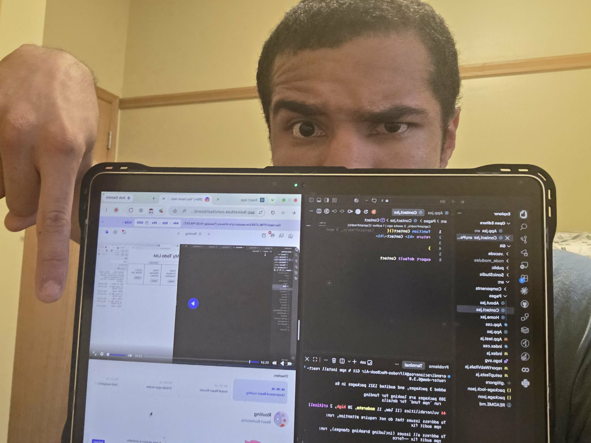 Aden pointing toward a laptop screen.